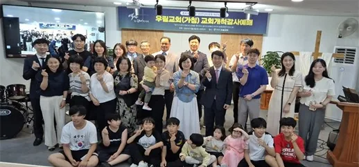 교회개척감사예배 현수막 아래 함께 선 성도와 내빈들